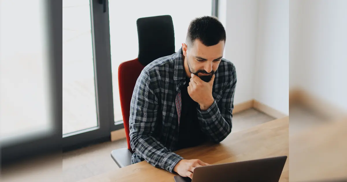 A man using a laptop on his desk, checking out the AFA dating site