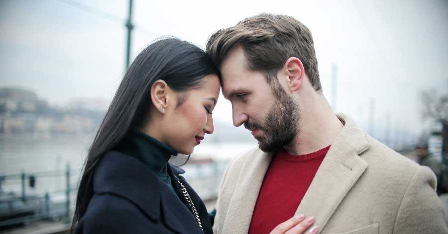 A man looking at her Asian partner.