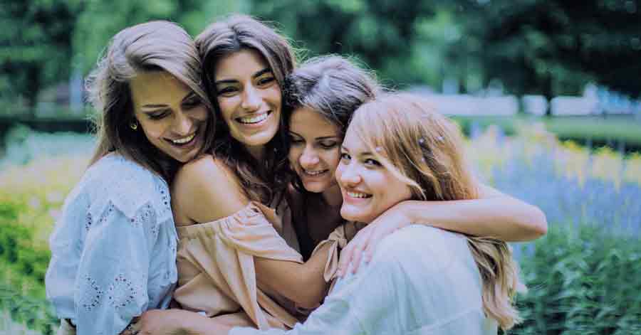 A photo of women hugging one another.