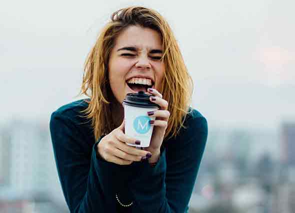 sitting woman with cup in hand, laughing