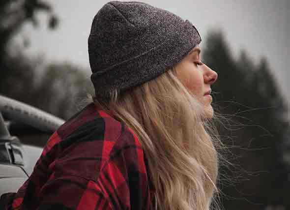 woman wearing beanie with hair blowing in the wind