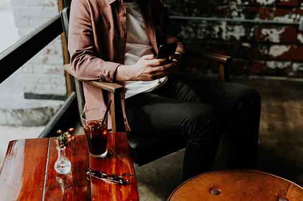 man sitting with phone in hand